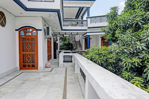 an exterior view of a house with a wooden door at Hotel O Shiva Grand in Chinhat