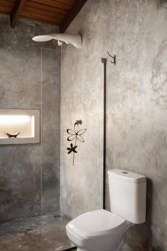 a bathroom with a toilet and a glass shower at Sattva Pousada in Pirenópolis