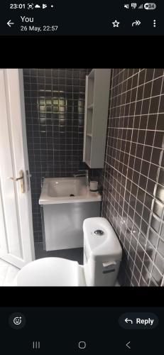 a bathroom with a white toilet and a sink at MPD Deluxe Suites in Kakamega
