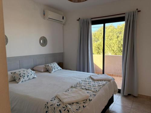 a bedroom with a bed and a large window at Los Aromos Sinsacate in Sinsacate