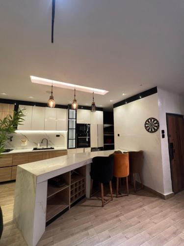 a large kitchen with a large counter and chairs at Bgold home Apartment in Lekki