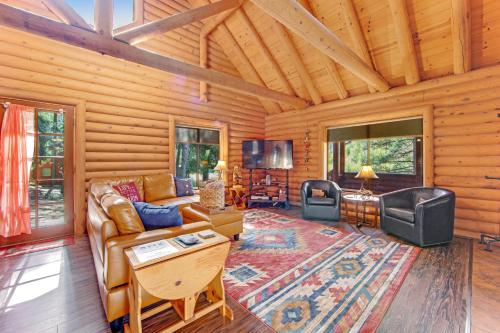 a living room with a couch and a tv in a log cabin at Deer Lane Lodge in Idyllwild