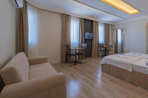 a hotel room with a bed and a couch at Karacan Hotel - Dalaman Airport in Dalaman