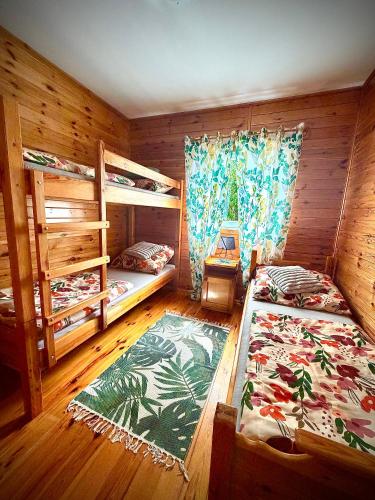 a bedroom with two bunk beds and a rug at Letniskowy Domek Paullo in Słajszewo