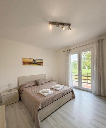 a bedroom with a bed and a large window at Le 4 Rondini in Spello