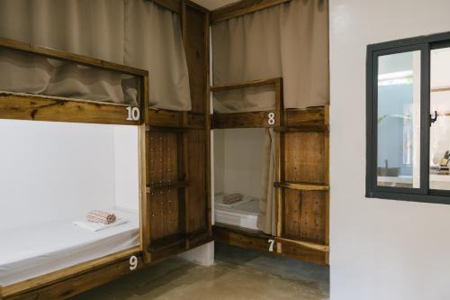 a room with two bunk beds and a window at Villa Gumamela Siargao in Catangnan