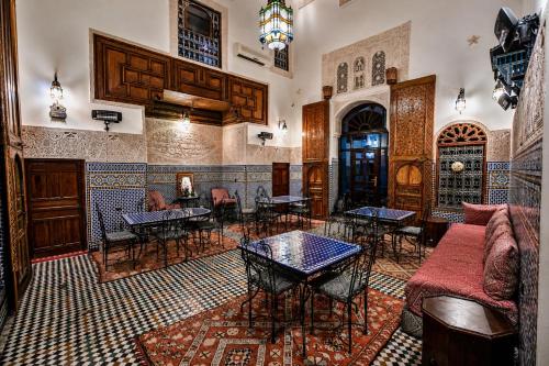 a living room with a couch and tables and chairs at Riad Fes Aicha & SPA in Fez