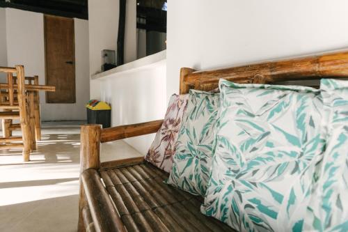 a wooden bench with pillows on it in a room at Villa Gumamela Siargao in Catangnan