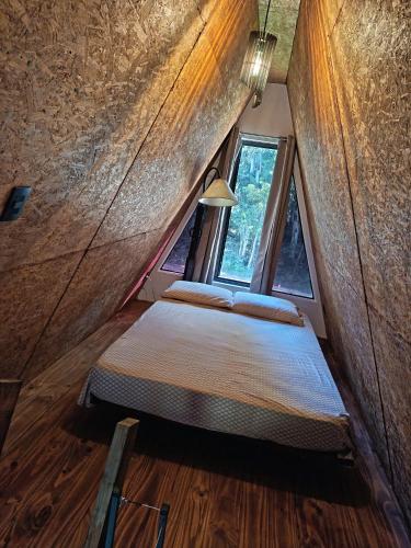 two beds in a small room with a window at Alpinas del bosque II in Maldonado