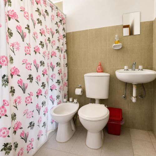 a bathroom with a toilet and a sink at El Crestón Hotel in Coronel Moldes