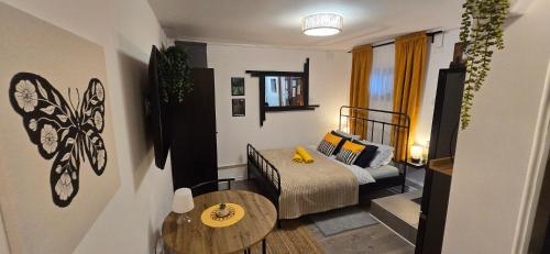 a small bedroom with a bed and a table at Studio apartman King with private jacuzzi and sauna in Štakorovec