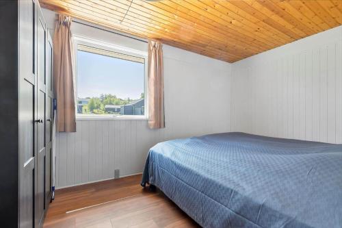 a bedroom with a blue bed and a window at 8599-Glesborg-Amagervej-4 in Glesborg