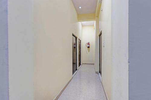 a hallway with white walls and a row of doors at Hotel O City View in Alīgarh