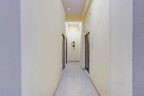 a corridor of an office building with white walls at Hotel O City View in Alīgarh