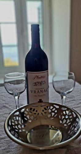 a bottle of wine and two glasses on a table at Apartman Alba in Petrovac na Moru