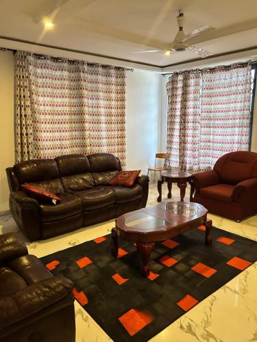 ein Wohnzimmer mit Ledersofa und Couchtisch in der Unterkunft Vip holiday inn in Aiyimensa