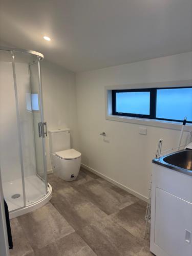 a bathroom with a shower and a toilet and a sink at Cottage Lifestyle in Fernside
