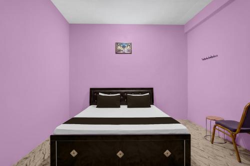 a bedroom with a large bed with purple walls at SPOT ON Pk Hotel & Restaurant in Meja