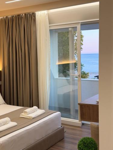a bedroom with a bed and a view of the ocean at Zhiti Waves in Durrës