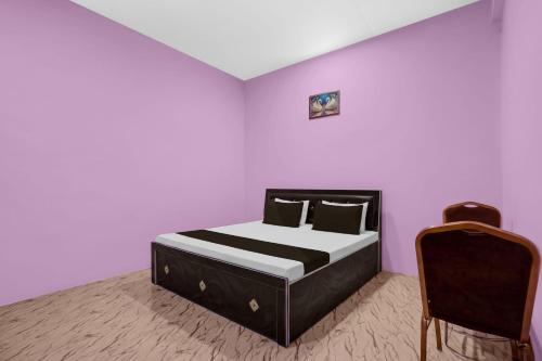a bedroom with a bed and a chair in it at SPOT ON Pk Hotel & Restaurant in Meja