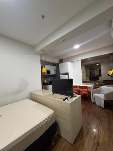 a bedroom with two beds and a living room at Flat Hotel S4 - Aguas Claras in Brasília