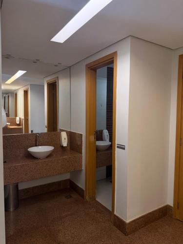 a bathroom with two sinks and a mirror at Flat Hotel S4 - Aguas Claras in Brasília