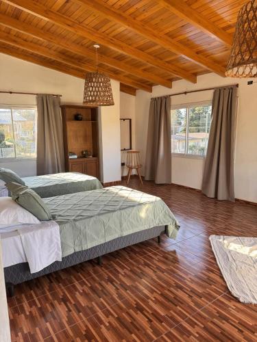a bedroom with a bed and wooden floors and windows at Aurea san antonio in San Antonio de Arredondo