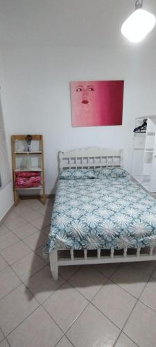 a bedroom with a bed and a painting on the wall at Hospedaje Entre Amigos in Comalcalco