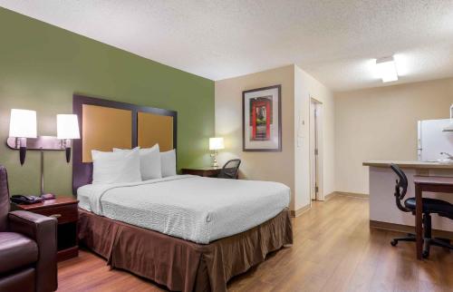 a hotel room with a large bed and a desk at Extended Stay America Select Suites - Raleigh - RDU Airport in Morrisville