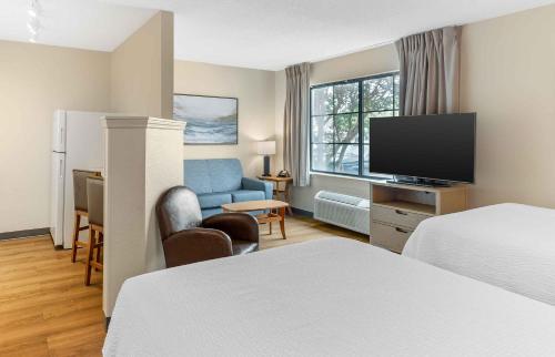 a hotel room with a bed and a flat screen tv at Extended Stay America Suites - Melbourne - Airport in Melbourne