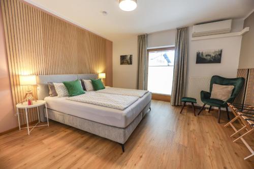 a bedroom with a bed and a chair and a window at Ferienwohnung BGD in Berchtesgaden