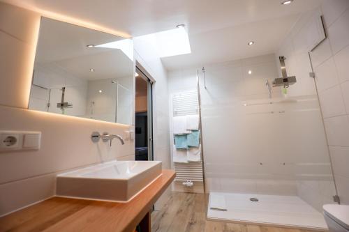 a white bathroom with a sink and a shower at Ferienwohnung BGD in Berchtesgaden