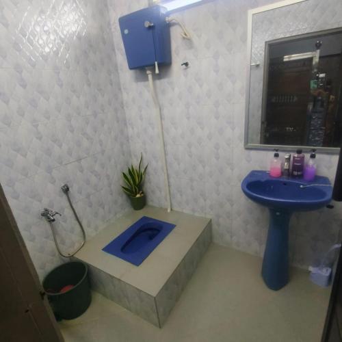 a bathroom with a blue sink and a bath tub at Quddus Inn villa in Wakaf Baharu