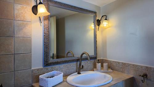 a bathroom with a sink and a mirror at Almira Prassa Beach House Kimolos in Prasonísi