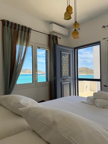 a bedroom with a bed with a view of the ocean at Almira Prassa Beach House Kimolos in Prasonísi
