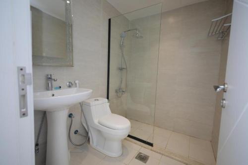 a bathroom with a toilet and a shower and a sink at 12 Durrat Al Arous - Rose Beach Villas in Durat Alarous