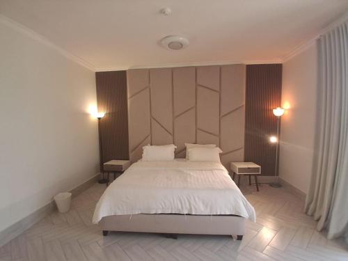 a bedroom with a large white bed and two tables at 12 Durrat Al Arous - Rose Beach Villas in Durat Alarous