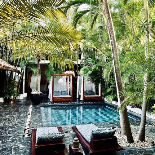 a swimming pool with palm trees in a resort at Tribal Hotel in Granada