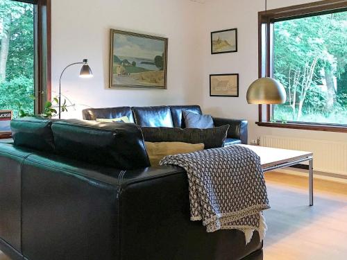 a black leather couch in a living room with a table at 6 person holiday home in Nykøbing M in Hesselbjerg