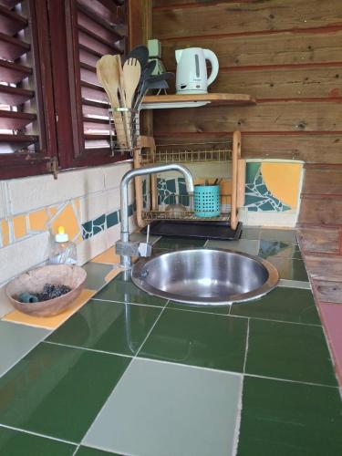 a kitchen counter with a sink in a kitchen at A Kaz Robinson in Sainte-Luce