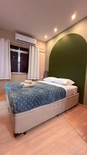 a bedroom with a large bed with a green wall at Studio no Centro do Rio l Próximo ao Metrô e VLT in Rio de Janeiro