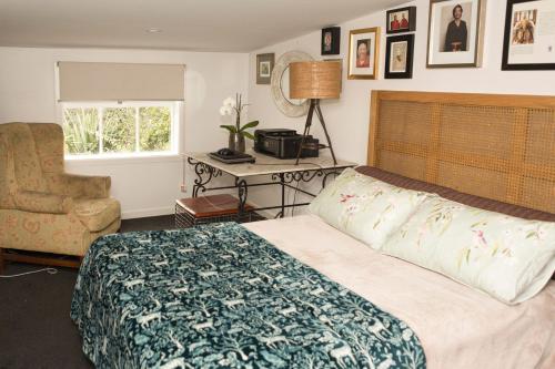a bedroom with a bed and a chair and a window at Nyima Tashi Buddhist Centre in Auckland