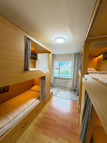a room with three bunk beds and a window at GG Hostel MONGOLIA 지지호스텔 몽골 in Ulaanbaatar