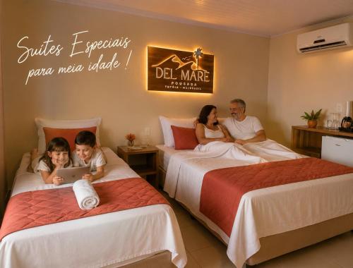 eine Familie sitzt auf Betten in einem Hotelzimmer in der Unterkunft Pousada Del Mare in Tutóia