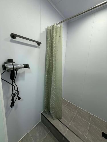 a shower in a bathroom with a shower curtain at GG Hostel MONGOLIA 지지호스텔 몽골 in Ulaanbaatar