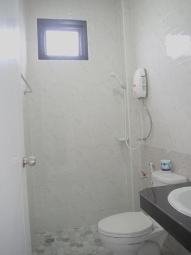 a white bathroom with a toilet and a sink at บ้านรวมสุข the Happiness in Chiang Kham