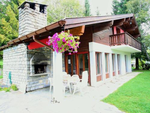 een huis met een open haard en een balkon met bloemen bij Spacious chalet in Randogne near Crans Montana in Randogne
