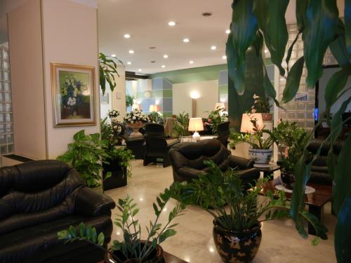a lobby with couches and potted plants at Delle Nazioni Milan Hotel in Milan