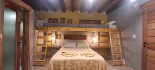 a bedroom with a bed with two bunk beds at Ocres de mi Tierra in Tilcara