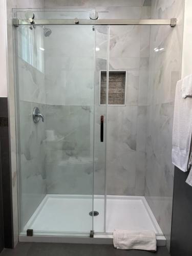 a shower with a glass door in a bathroom at Lotus Motel in Inglewood